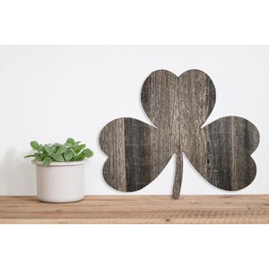 May include: A wooden shamrock cutout with a rustic gray finish. The shamrock is made of reclaimed wood and has a natural, weathered look.