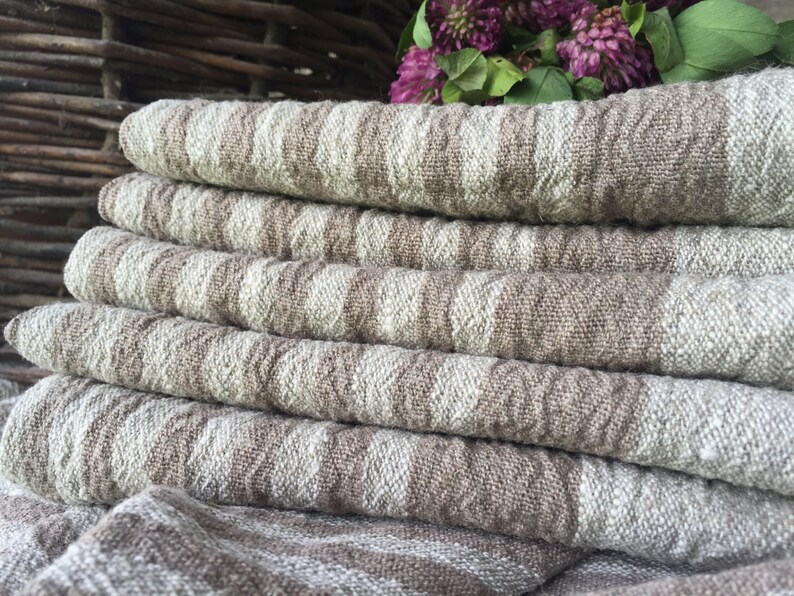 May include: A stack of six brown and white linen tea towels with a woven pattern. The towels are folded and stacked on top of each other.