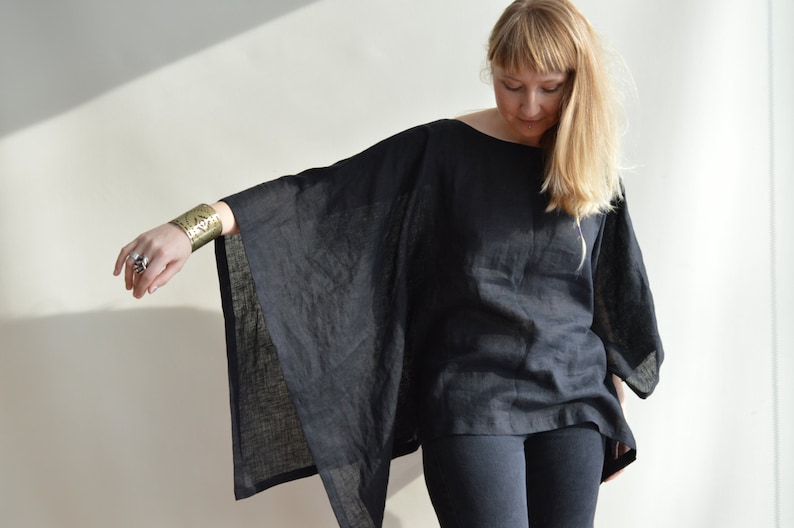 May include: A black linen top with a wide, flowing silhouette. The top has a relaxed fit and a simple, elegant design.