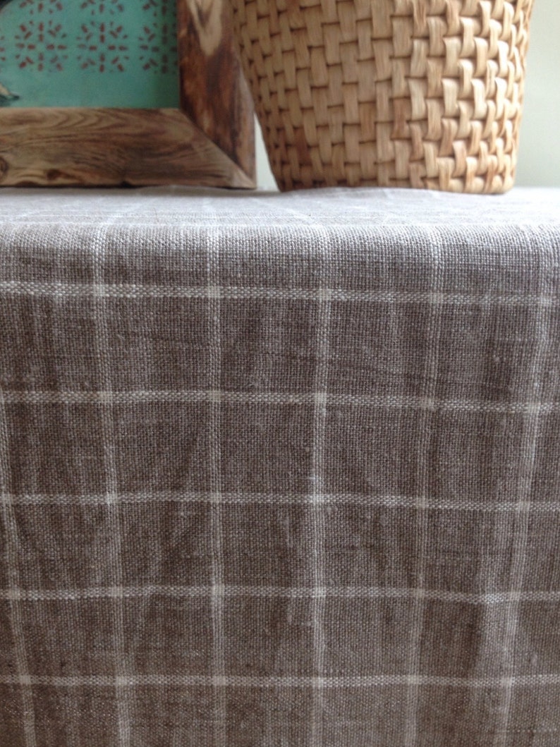 May include: A brown linen tablecloth with a white checkered pattern. The tablecloth is smooth and has a subtle sheen.