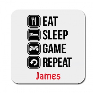May include: White square coaster with rounded corners. Black icons and text read "EAT SLEEP GAME REPEAT". The name "James" is printed in red at the bottom. A fun gift for gamers.