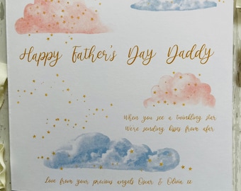 Pode incluir: Um cartão de Dia dos Pais com nuvens em aquarela rosa e azul, adornado com estrelas douradas. O cartão diz "Happy Father's Day Daddy" em letras douradas, com uma mensagem e os nomes dos remetentes.