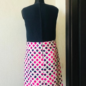 May include: A sleeveless dress with a black knit top and a white skirt with pink and black polka dots.