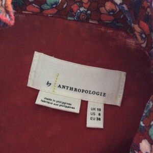 Pu&ograve; includere: Un'etichetta bianca con testo nero che recita "by Anthropologie" e "made in philippines/fabrique aux philippines". L'etichetta include anche le informazioni sulle taglie: UK 10, US 6, EU 38.