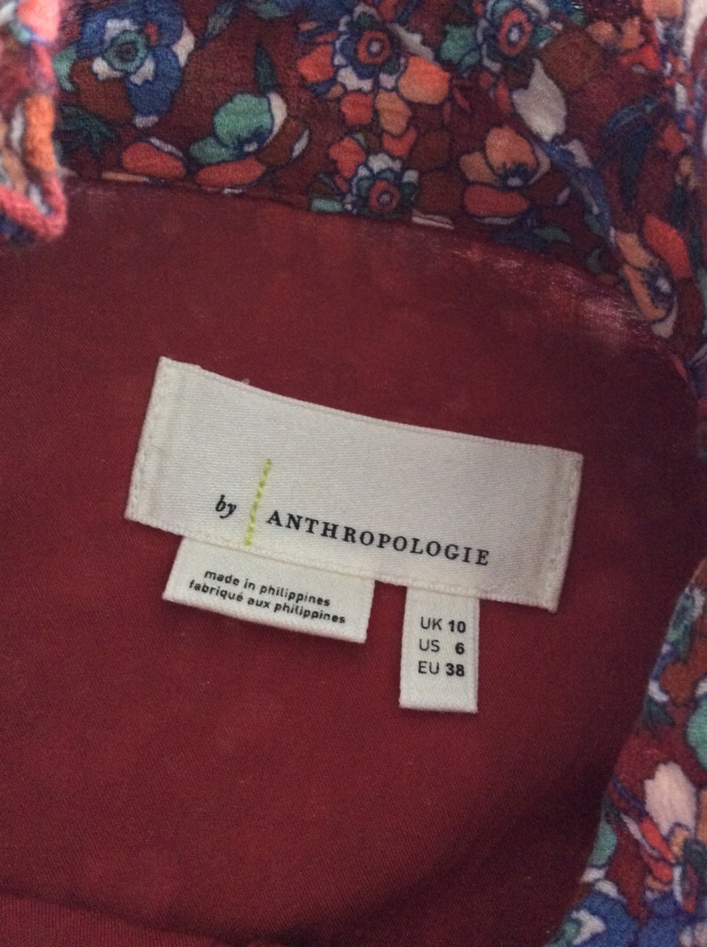 Pu&ograve; includere: Un'etichetta bianca con testo nero che recita "by Anthropologie" e "made in philippines/fabrique aux philippines". L'etichetta include anche le informazioni sulle taglie: UK 10, US 6, EU 38.
