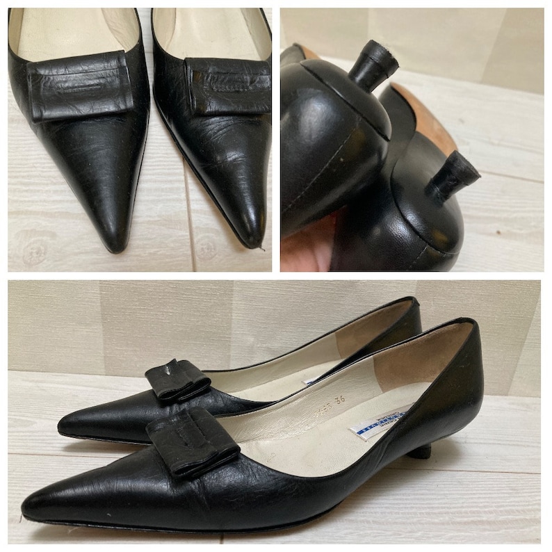 May include: Black leather heeled pumps with a pointed toe and a small bow detail on the vamp. The shoes have a kitten heel and are size 36.