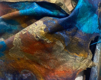 Può includere: Una sciarpa di lana con motivo astratto blu, turchese e oro. La sciarpa è drappeggiata sul collo di un manichino.