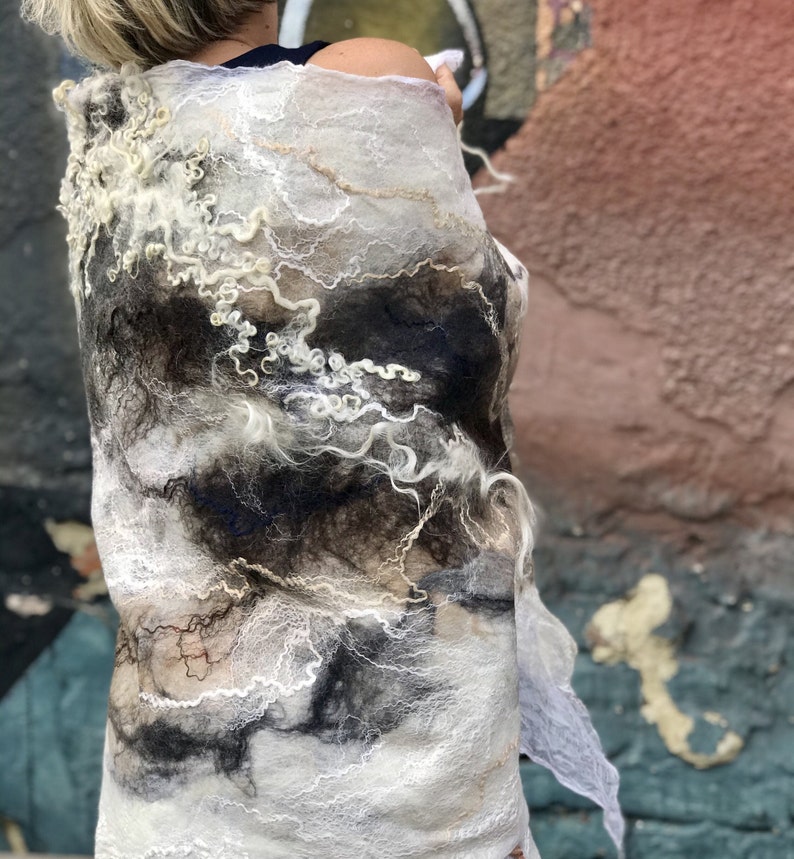May include: A white and black wool shawl with a unique, abstract design. The shawl is made of soft, flowing fabric and has a delicate, ethereal look.