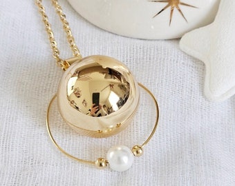 Gold pregnancy bola with its delicate beaded ring on a gold chain
