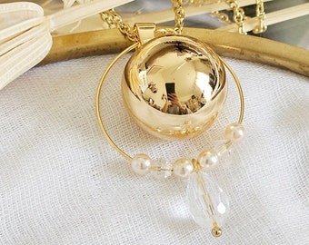 Gold pregnancy bola surrounded by a delicate ring of crystal and pearly beads on a gold chain