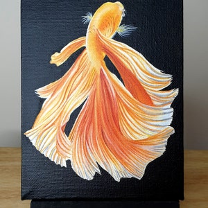 May include: A painting of a bright orange betta fish with long, flowing fins against a black background. The fish is depicted in a dynamic pose, with its fins spread out.