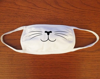 May include: White cotton face mask with a black cat nose and whiskers design.