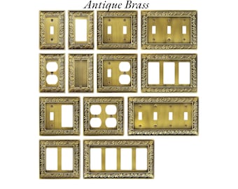 May include: Antique brass switch plates in various configurations, including single and double switch plates, outlet covers, and multi-switch plates. Each plate features an ornate, embossed border design. The text "Antique Brass" is at the top.