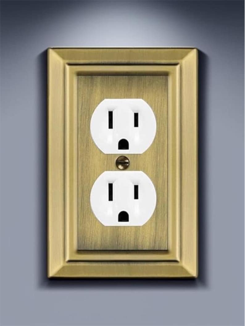 May include: A brass wall plate with a white double electrical outlet.