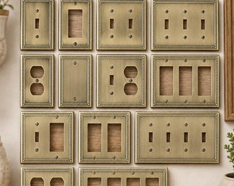 May include: A collection of antique brass switch and outlet covers featuring a beaded border design. The set includes various configurations for single, double, triple, and quadruple switches and outlets, all crafted from solid metal with matching screws.
