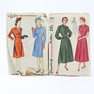 May include: Two vintage sewing pattern envelopes. The left envelope, Du Barry 5561, shows illustrations of a red suit and a blue suit. The right envelope, Simplicity 2587, displays illustrations of a green striped dress and a solid red dress.