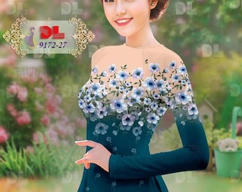 May include: A teal blue dress with a floral pattern featuring white and blue flowers. The dress has long sleeves and a round neckline. The dress is photographed against a blurred background of green foliage.