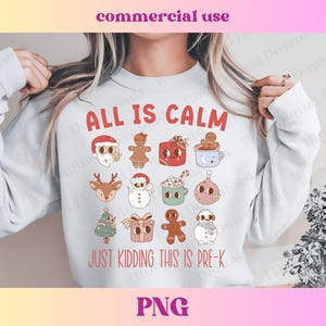 Puede incluir: Una sudadera blanca con un diseño navideño. El texto "All is Calm" está impreso en rojo y negro. Debajo del texto hay varias ilustraciones con temática navideña, incluyendo un hombre de jengibre, un muñeco de nieve y un reno. El texto "Just Kidding This is Pre-K" está impreso en rojo y negro debajo de las ilustraciones.
