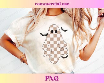 May include: A white t-shirt with a checkered ghost graphic and bats flying around it. The ghost has two eyes and a checkered pattern.