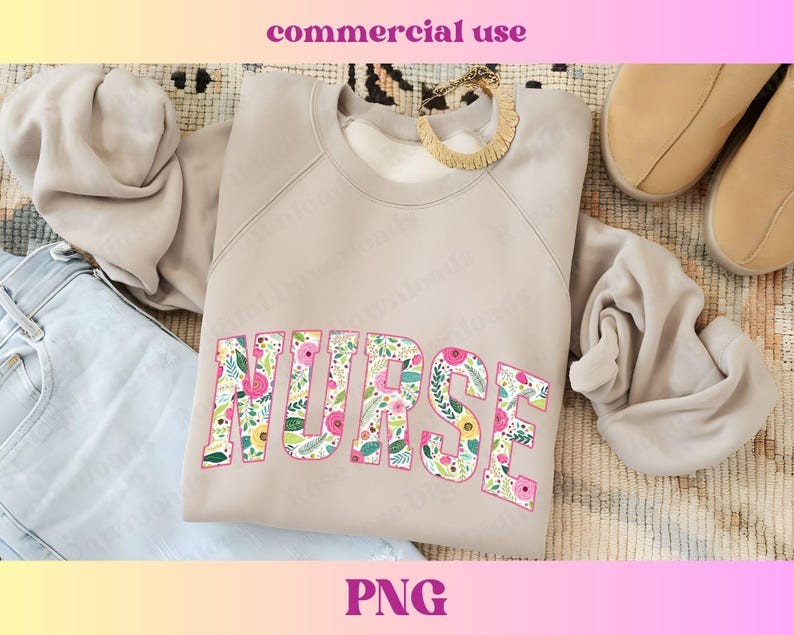 Peut inclure: Un sweat-shirt beige clair avec le mot "NURSE" imprim&eacute; en grandes lettres audacieuses. Les lettres sont remplies d'un motif floral dans des tons de rose, jaune, vert et bleu.