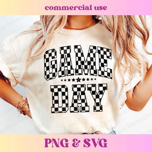 May include: A white t-shirt with a black and white chequered design that says "GAME DAY" in bold letters.