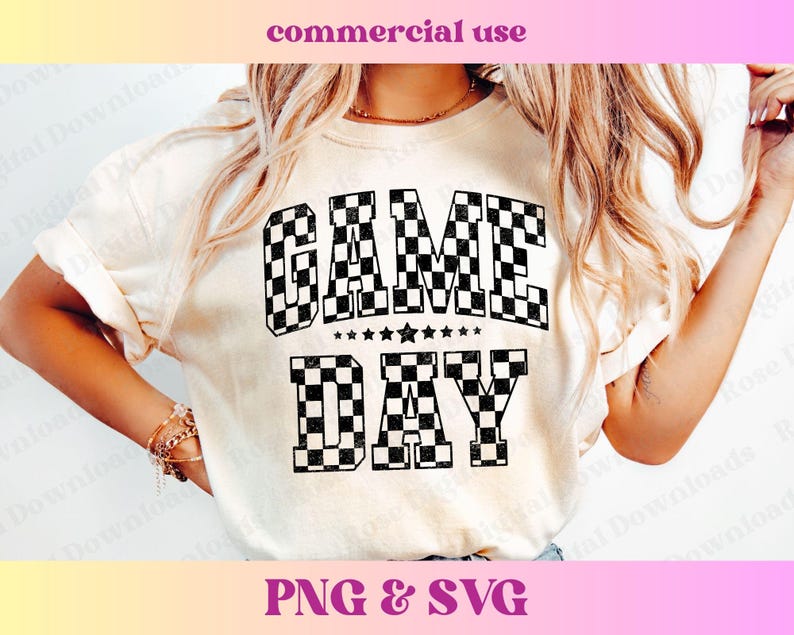 May include: A white t-shirt with a black and white chequered design that says "GAME DAY" in bold letters.