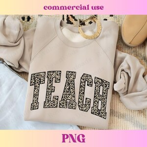 Peut inclure: Un sweat-shirt beige clair avec le mot "TEACH" imprim&eacute; en noir avec un motif l&eacute;opard.