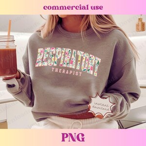May include: A gray sweatshirt with the text "Respiratory Therapist" in floral letters. The text is in a pink, yellow, and green floral pattern.