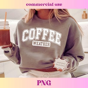 Può includere: Una felpa grigia con la scritta "COFFEE WEATHER" in lettere bianche. La felpa è indossata da una persona che tiene un bicchiere di caffè.