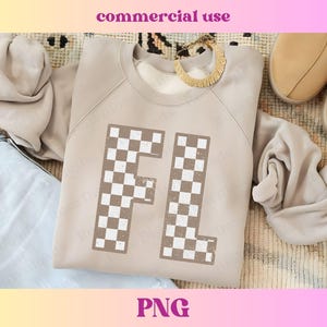 Puede incluir: Una sudadera marrón claro con un diseño a cuadros de las letras "FL" en la parte delantera.