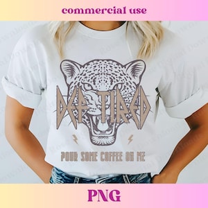 May include: White t-shirt featuring a brown and white leopard print graphic. The graphic reads "Da Tired" and "Pour Some Coffee On Me".