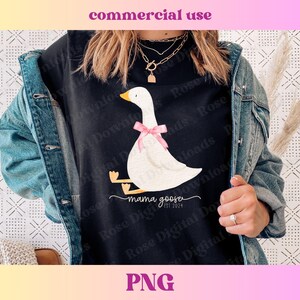 May include: Black t-shirt with a white goose illustration wearing a pink bow. The text "mama goose est 2024" is below the goose. The image also includes the words "commercial use" and "PNG" at the top and bottom.
