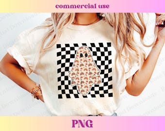 May include: A white t-shirt with a checkered pattern and a ghost with rainbow accents. The ghost has a cute face and is wearing a checkered pattern.