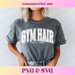 Peut inclure: Un t-shirt gris avec le texte "GYM HAIR don't care" en lettres blanches vieillies.