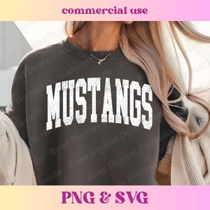 Pu&ograve; includere: Una felpa grigia scura con la parola "MUSTANGS" stampata in bianco con un aspetto usurato e vintage.
