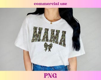 May include: White t-shirt with a camouflage print "MAMA" design and a small bow.