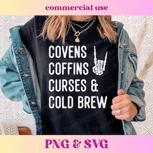 May include: A black t-shirt with white text that reads "Covens Coffins Curses & Cold Brew" with a skeleton hand making a rock and roll sign.