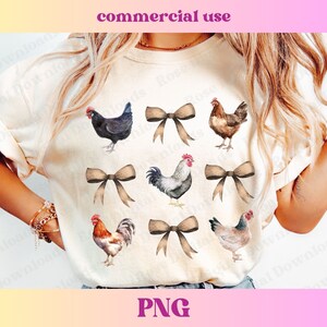 May include: A white t-shirt with a watercolor design of chickens and bows. The chickens are in various poses, some with their wings spread and some with their heads tilted. The bows are in a variety of colors, including brown, pink, and blue.