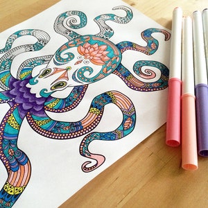 Puede incluir: Una ilustraci&oacute;n detallada de un pulpo con intrincados patrones en tonos de azul, morado, naranja y amarillo. El pulpo est&aacute; dibujado en papel blanco y rodeado de marcadores de colores.