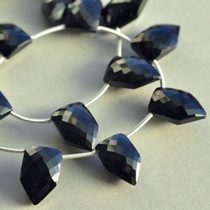 Peut inclure: Un collier de perles de pierres précieuses noires, chaque perle est facetée et en forme de larme. Les perles sont enfilées sur un fil d'argent.