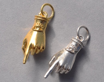 May include: Two gold and silver charm pendants in the shape of a hand pointing with an evil eye design.