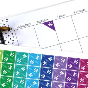 May include: A sheet of colourful stickers with a white asterisk design. The stickers are arranged in a rainbow pattern.