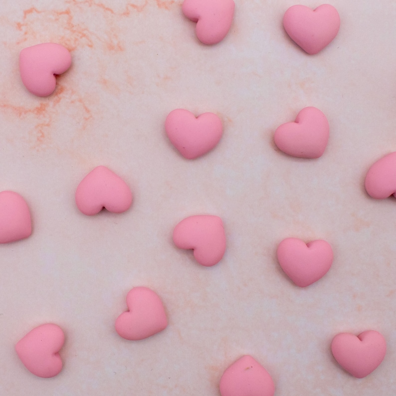 K&ouml;nnte beinhalten: Ein rosa Hintergrund mit einem Muster aus rosa Herzen.