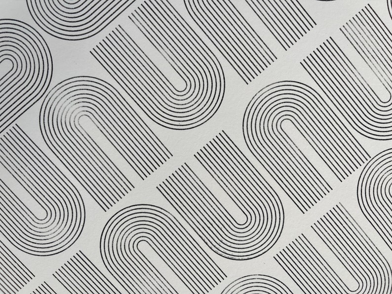 K&ouml;nnte beinhalten: Abstraktes Muster mit sich wiederholenden schwarzen, bogenf&ouml;rmigen Linien auf hellgrauem Hintergrund. Das Design erzeugt ein Gef&uuml;hl von Bewegung und Rhythmus, geeignet f&uuml;r verschiedene dekorative Anwendungen. Die Linien sind gleichm&auml;&szlig;ig angeordnet und bilden eine moderne, geometrische &Auml;sthetik.