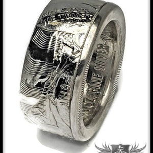 May include: A silver ring made from a 1971-S silver dollar coin. The ring features the inscription "IN GOD WE TRUST" and "ONE FINE SILVER DOLLAR 1971-S".
