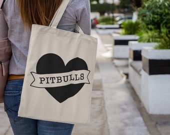 May include: A white tote bag with a black heart and the text "PITBULLS" on a banner.