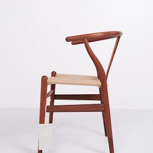 May include: A wooden chair with a woven seat and a curved backrest. The chair is made of dark wood and has a light-colored woven seat. The chair is a classic design, suitable for dining or as an accent piece.