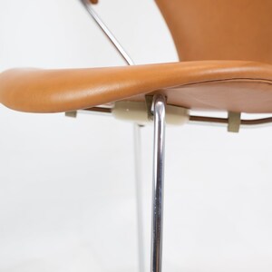 Puede incluir: Un primer plano de una silla de cuero marr&oacute;n con un marco cromado. La silla tiene un respaldo curvo y un asiento c&oacute;modo. La silla est&aacute; en buen estado y ser&iacute;a una gran adici&oacute;n a cualquier hogar.