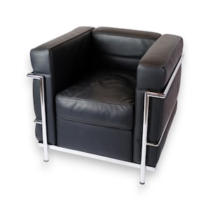 Könnte beinhalten: Schwarzer Ledersessel mit kastenförmigem Design. Der Stuhl hat eine niedrige Sitzfläche, eine quadratische Rückenlehne und Armlehnen. Der Rahmen ist aus poliertem Chrom mit vier Beinen. Moderner, minimalistischer Stil.