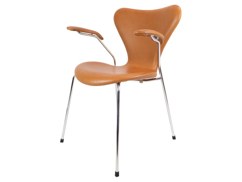 Puede incluir: Una silla de cuero marr&oacute;n con patas y brazos cromados. La silla tiene un respaldo curvo y un asiento c&oacute;modo.